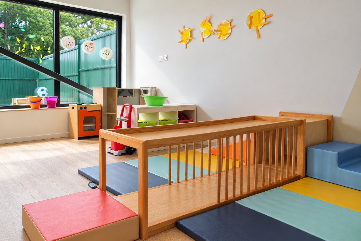 Salle de motricité lumineuse avec parcours en bois, tapis colorés et jeux d'imitation