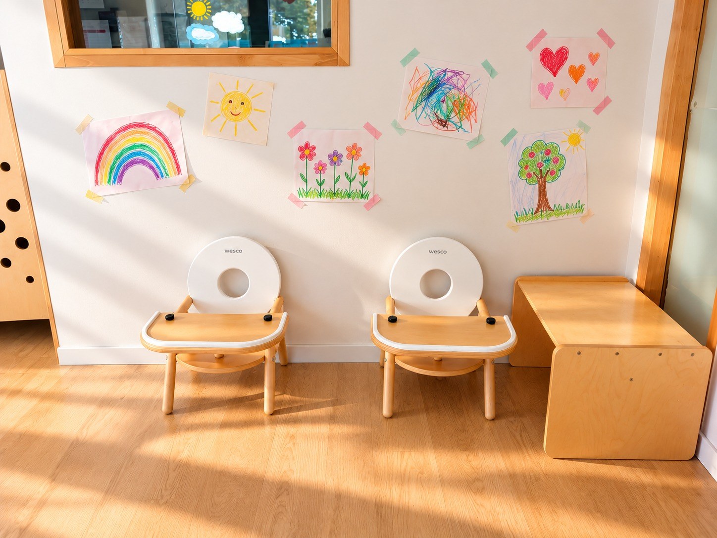 Deux petites chaises de repas en bois devant un mur décoré de dessins colorés
